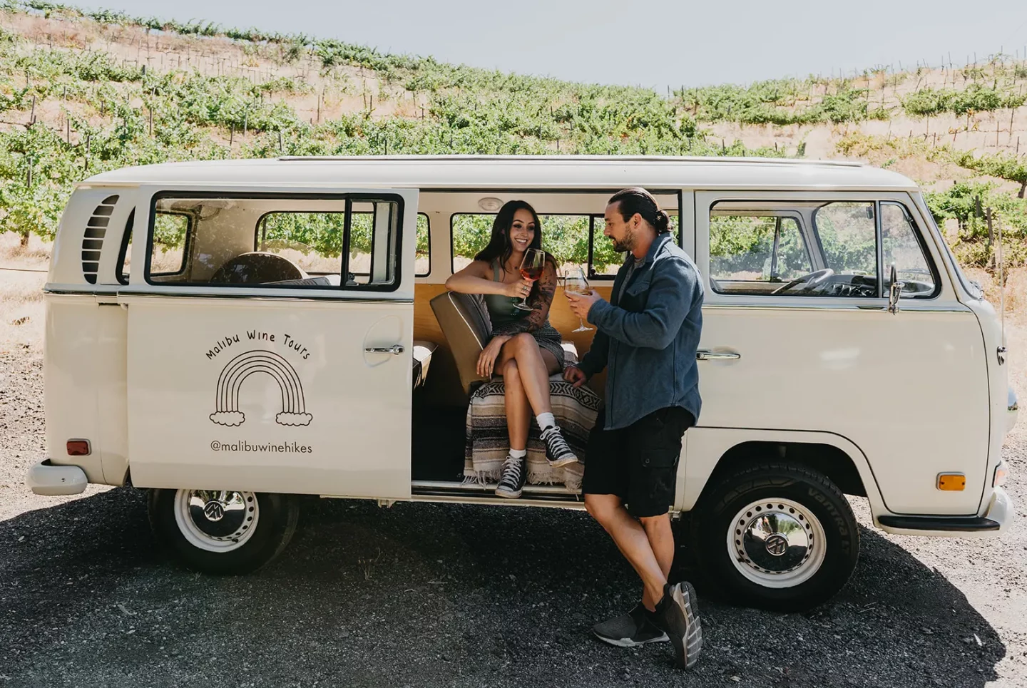 couple sipping wine in vw bus on wine tour